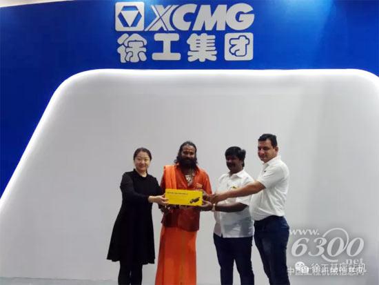 工作人員向購(gòu)機(jī)客戶贈(zèng)送徐工產(chǎn)品模型